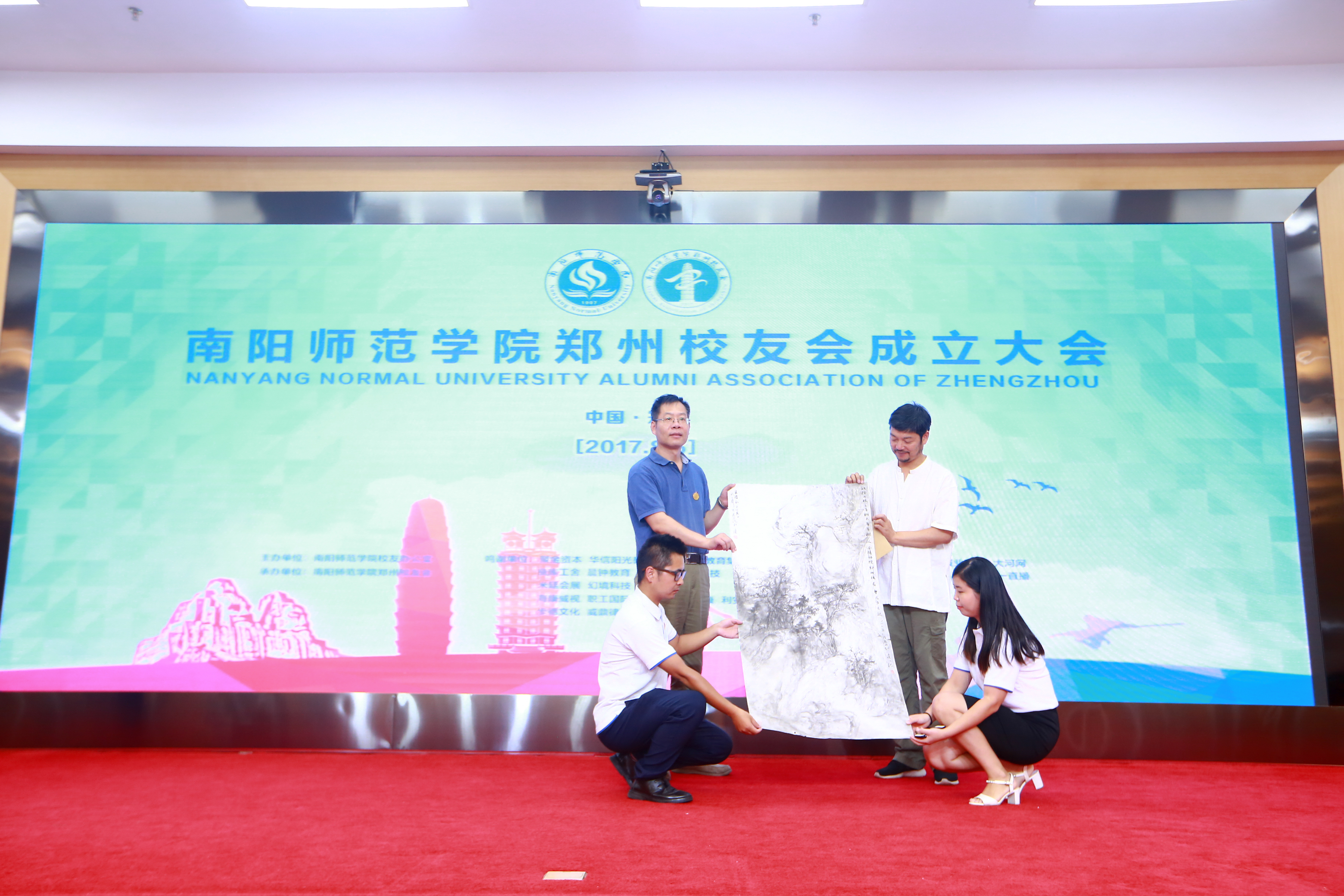 6.纪委书记于继武接收校友会赠予母校的书画作品.jpg