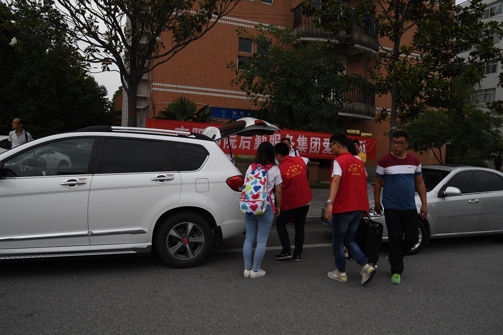 大学生志愿者帮助毕业生装行李.JPG